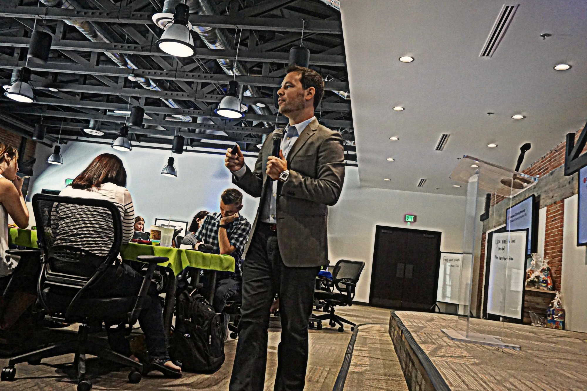 Dominic Bartola presenting among audience tables at an APS event