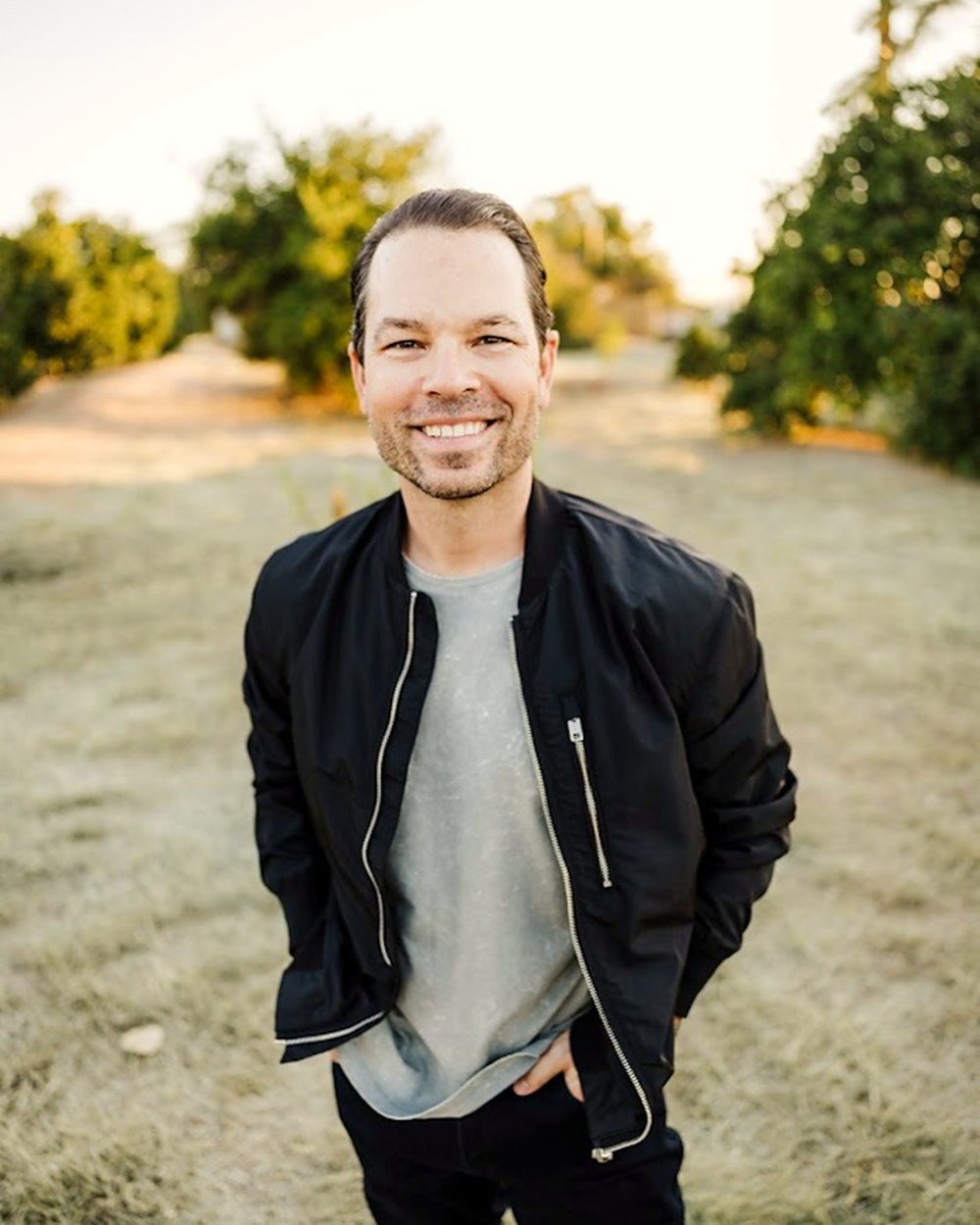 Dominic Bartola standing outdoors in a black jacket with his hands in his pockets