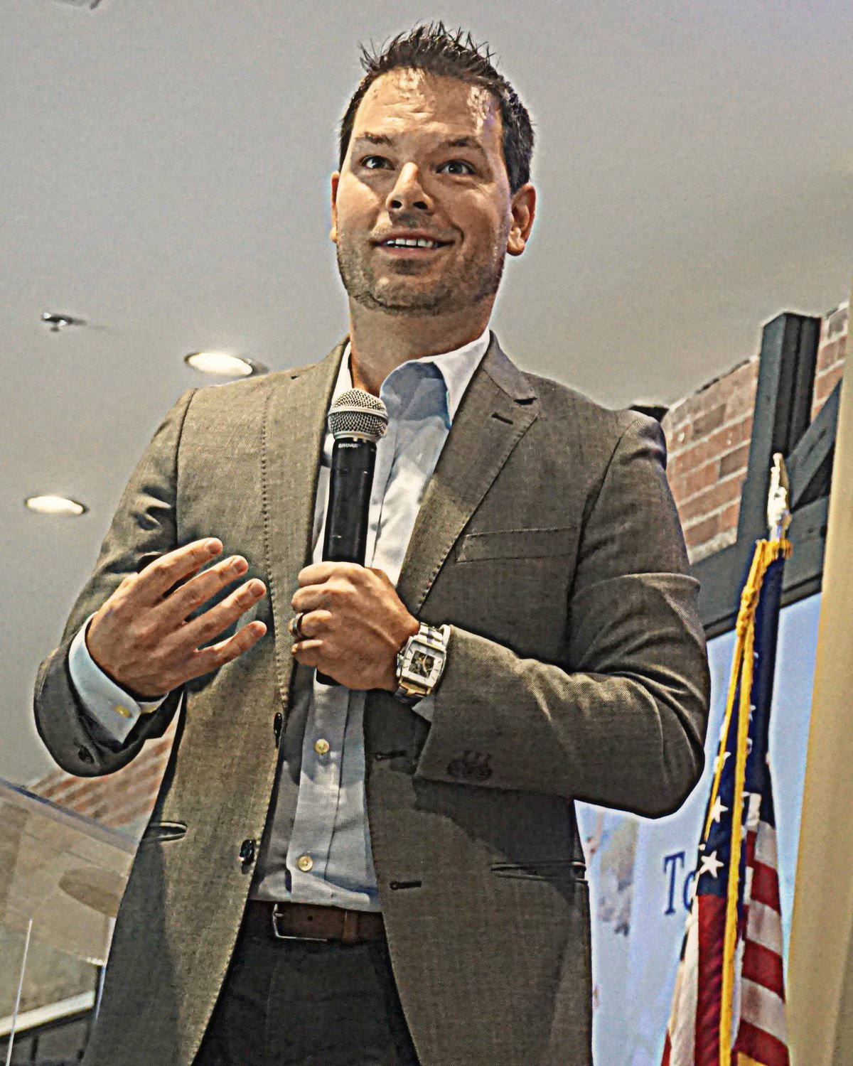 Close-up of Dominic Bartola speaking with a handheld microphone